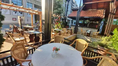 a white table with a vase of flowers on a balcony at Hotel Villa Bora in Sunny Beach
