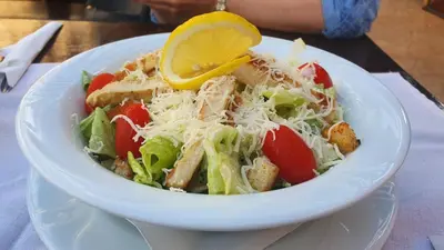 a white bowl of salad with a lemon on top at Hotel Villa Bora in Sunny Beach