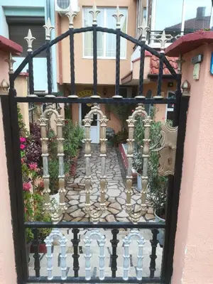 a gate to a building with flowers and plants at Guest House Hetodon in Sozopol