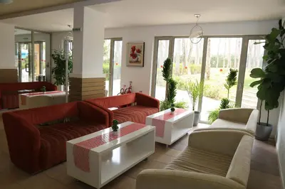 a living room with couches and tables and windows at Вилно селище 