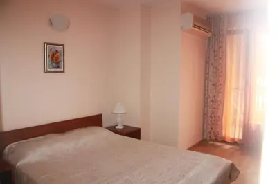 a bedroom with a bed and a window at Family Hotel Emilia in Sozopol