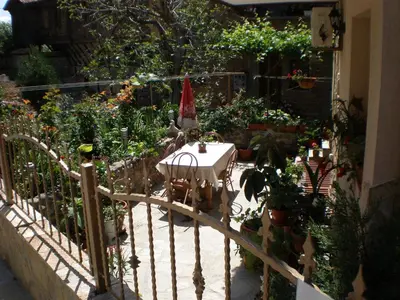 a garden with a table and some plants at Family Hotel Emilia in Sozopol