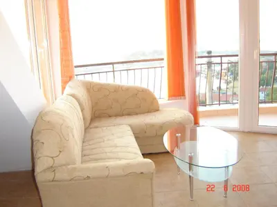 a living room with a couch and a glass table at Panoramic Penthouse Sozopol in Sozopol