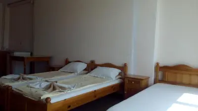 two twin beds in a room with two tables at Guest House Diamant in Sozopol