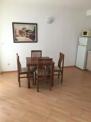 a dining room with a table and chairs and a refrigerator at Blue Summer in Sunny Beach