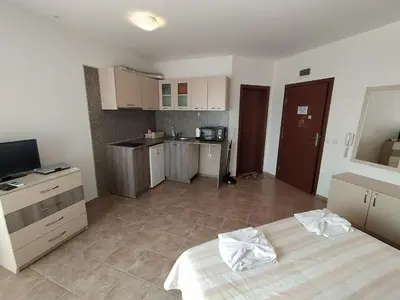 a room with a bed and a kitchen in it at Sunny Sands Studios in Burgas City