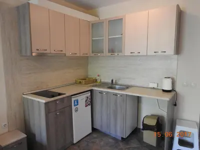 a small kitchen with wooden cabinets and a sink at Sunny Sands Studios in Burgas City