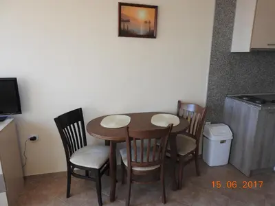 a wooden table and chairs in a kitchen at Sunny Sands Studios in Burgas City