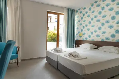 a bedroom with a bed with two towels on it at Ema Hotel in Sozopol