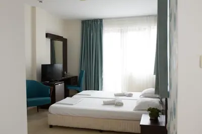 a hotel room with a bed and a window at Ema Hotel in Sozopol