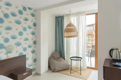 a living room with a chair and a window at Ema Hotel in Sozopol