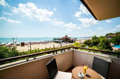 a balcony with a table and chairs and a view of the beach at Helena VIP Villas and Suites - Half Board in Sunny Beach