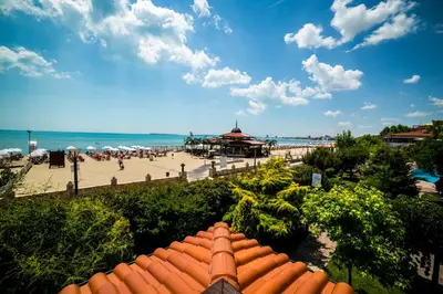 a view of a beach with a building and the ocean at Helena VIP Villas and Suites - Half Board in Sunny Beach