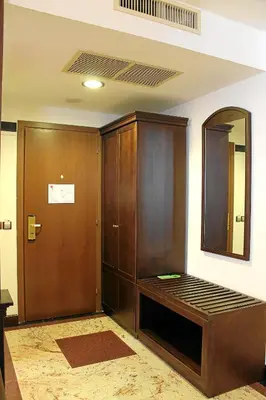 a room with a bed and a closet and a mirror at Helena VIP Villas and Suites - Half Board in Sunny Beach