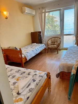 a bedroom with two beds and a chair and a window at Guest House Evin Rai in Byala