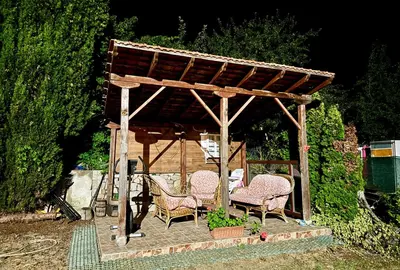 a wooden gazebo with chairs and a table at Guest House Evin Rai in Byala