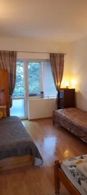 a bedroom with two beds and a large window at Guest House Evin Rai in Byala