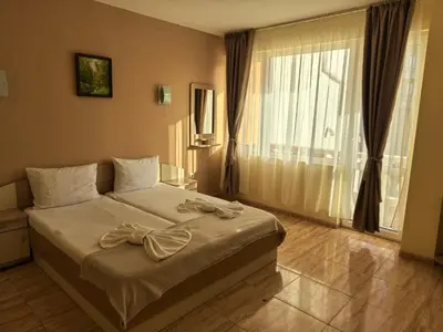 a bedroom with a bed with a bow on it at Family Hotel Alfa Vita in Sozopol