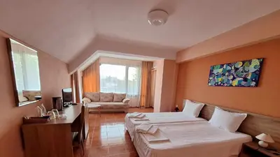 a hotel room with a bed and a couch at Guest House Starata Kushta in Lozenets