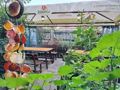 a garden with a table and benches and plants at Guest House Starata Kushta in Lozenets