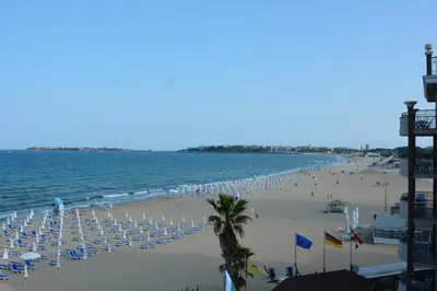 a beach with a lot of chairs and people on it at Golden Rainbow Beach Hotel in Sunny Beach
