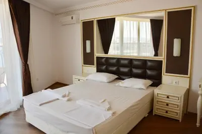 a bedroom with a large bed with a large mirror at Golden Rainbow Beach Hotel in Sunny Beach