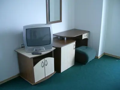a room with a tv and a desk with a chair at Hotel Levteri in Primorsko