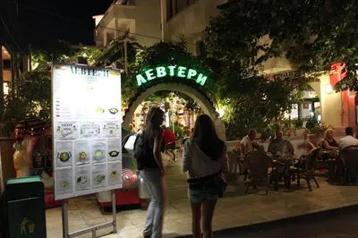 two women standing next to a sign in front of a restaurant at Hotel Levteri in Primorsko