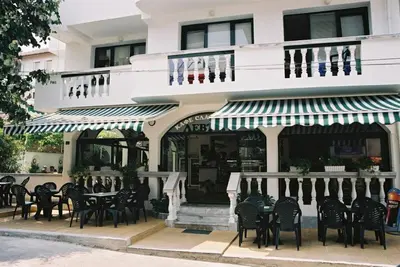 a restaurant with tables and chairs in front of a building at Hotel Levteri in Primorsko