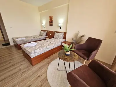 a living room with a couch and a chair at Family Hotel Diana in Tsarevo