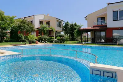 a large swimming pool in front of a building at Saint Stefan Villas in Sozopol