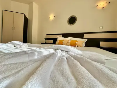 a large white bed with a white blanket on it at Menada Imperial Heights Villas in Sunny Beach
