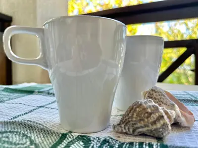 two white cups sitting on top of a table at Menada Imperial Heights Villas in Sunny Beach