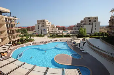 a large swimming pool in a city with buildings at Menada Luxor Apartments in Sveti Vlas