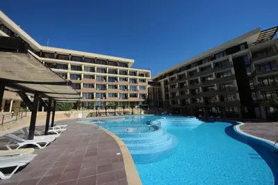 a large swimming pool in front of two buildings at Menada Luxor Apartments in Sveti Vlas