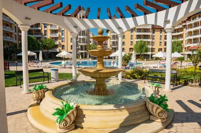 a fountain in the middle of a pool at a resort at Menada Royal Sun Apartments in Sunny Beach