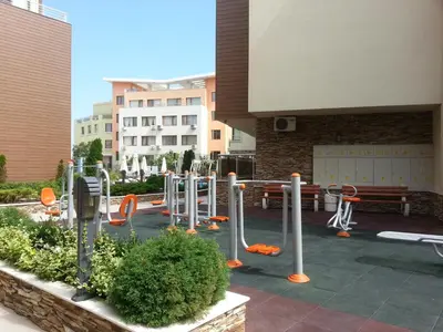 a park with a bunch of exercise equipment in front of a building at Menada Horyzont Apartments in Sozopol