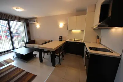 a small kitchen with a table and a dining room at Menada Horyzont Apartments in Sozopol