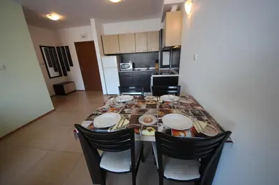 a dining room table with chairs in a kitchen at Menada Grand Kamelia Apartments in Sunny Beach