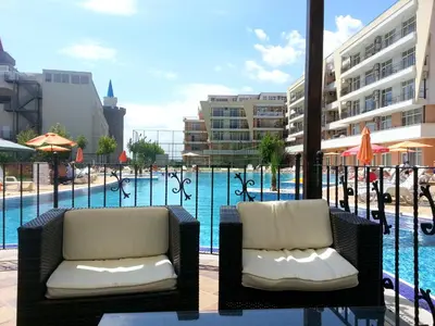 two chairs sitting in front of a swimming pool at Menada Grand Kamelia Apartments in Sunny Beach