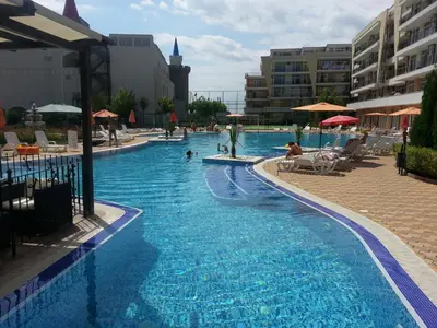 a large swimming pool with people in a resort at Menada Grand Kamelia Apartments in Sunny Beach