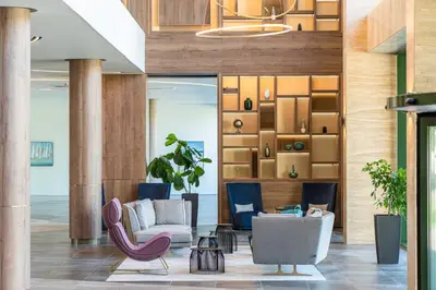 a lobby with two chairs and a couch at HVD Reina del Mar - Premium Spa Service & Free Parking in Obzor
