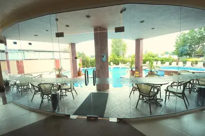 a cafeteria with tables and chairs and a swimming pool at Menada Apartments in Sunny Beach in Sunny Beach
