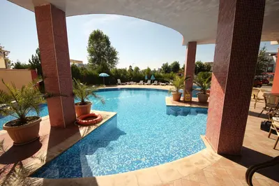a swimming pool in a resort with potted plants at Menada Apartments in Sunny Beach in Sunny Beach