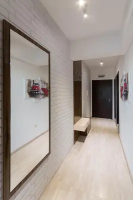 a mirror on the wall of a hallway with a bench at City Apartments Triumph in Varna City