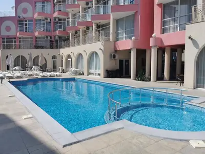 a swimming pool in front of a building at Rose Garden Omax Apartments in Sunny Beach