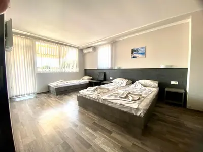 a bedroom with two beds and a large window at Guest house Napoli in Ravda