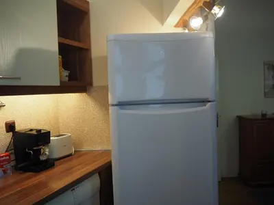 a white refrigerator in a kitchen next to a counter at Yoana Apartment in Varna City