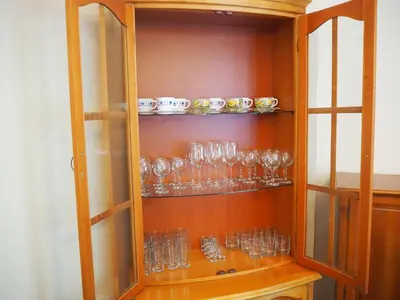 a cabinet filled with glasses on a shelf at Yoana Apartment in Varna City