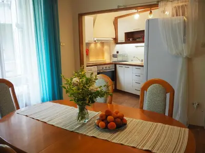 a kitchen with a table with a vase of oranges on it at Yoana Apartment in Varna City